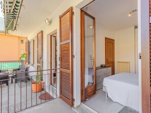 Ein Balkon mit Tisch und Stühlen, einem Blumentopf und Blick auf einen Pool.