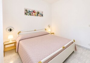 A bed with a quilted mattress, two bedside tables with lamps, and a wall-mounted mirror. - Stunning private villa for 6 people with A/C, WIFI, TV, patio and panoramic view (Santa Maria Del Focallo)