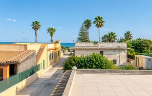 Ein Wohngebiet mit freiem Blick auf das Meer, Palmen und einem Ziegeldach.