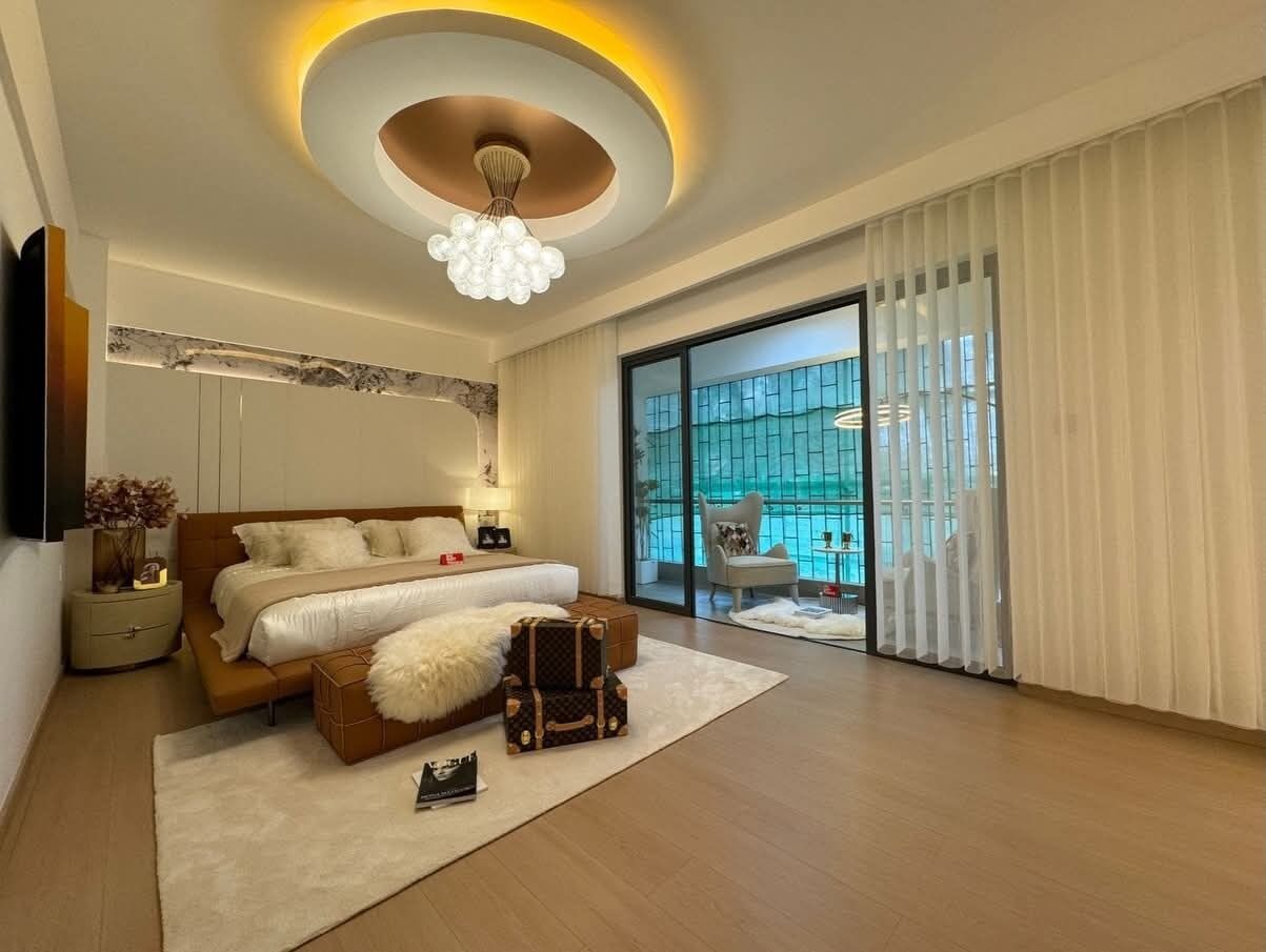 Un dormitorio moderno con una cama grande, una lámpara en el techo y vistas a una piscina a través de la puerta de cristal.