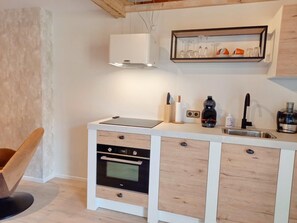 A compact kitchen with a built-in oven, a coffee machine, and a sink. - Pura Vida Suite: Enjoy Life! (Oud Ade)