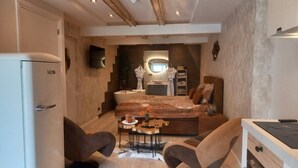 A compact bedroom with a bed, bedside tables, a desk, and a chair. - Pura Vida Suite: Enjoy Life! (Oud Ade)