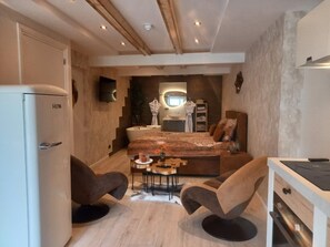 Ein kleines Schlafzimmer mit einem Bett, Nachttischen, einem Schreibtisch und einem Stuhl.