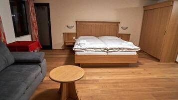 Ein Schlafzimmer mit einem Bett, einem Schlafsofa, einem kleinen Tisch und einem Kleiderschrank.