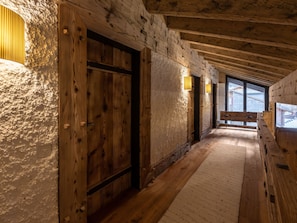 Ein Holzflur mit einer großen Tür und Wandleuchten.