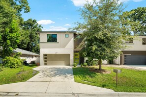 A modern two-story house with a garage, a front yard, and a mailbox. - Arlington Park Oasis 4 Bedroom Home (Sarasota)