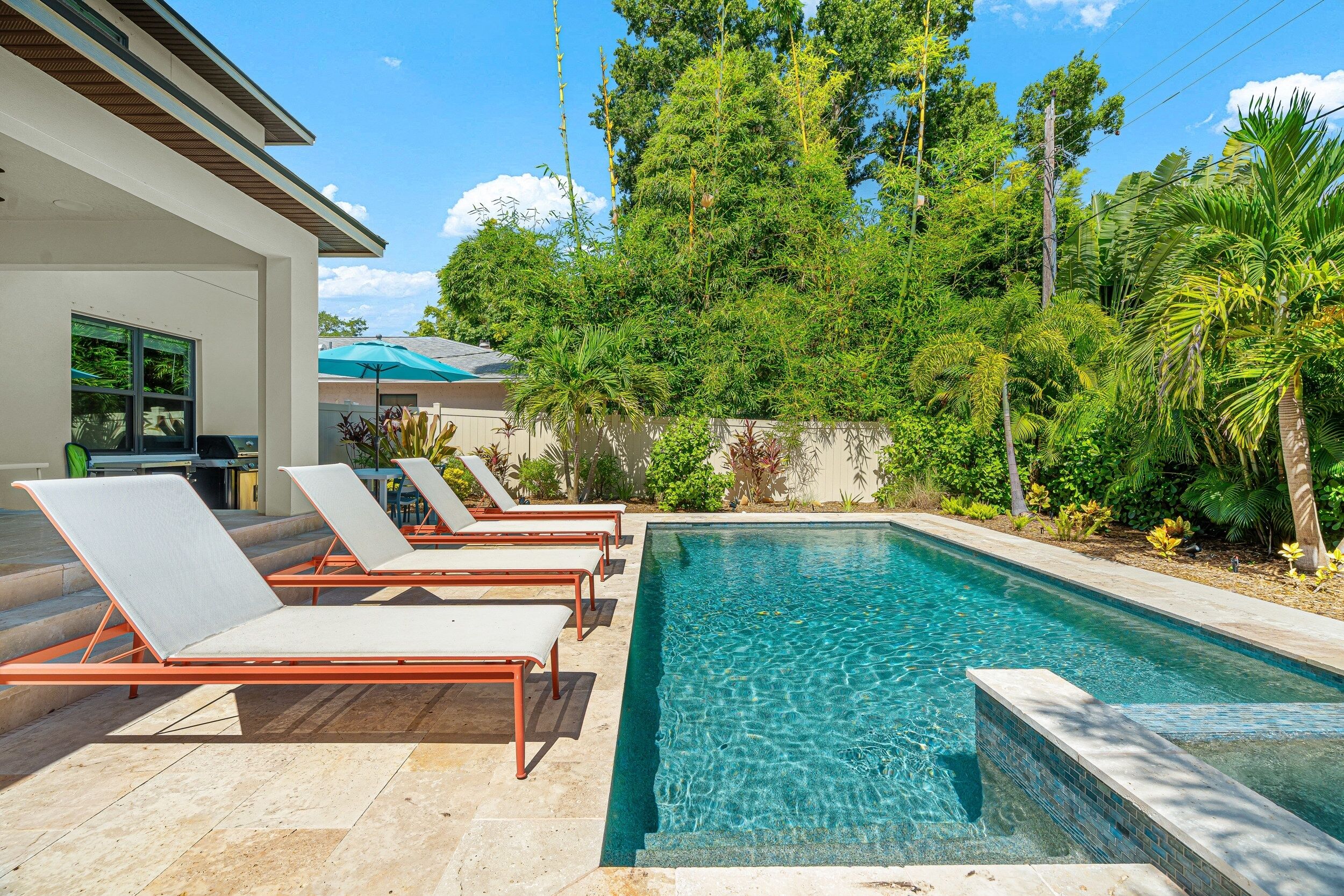 Une piscine avec des chaises longues et un espace patio.
