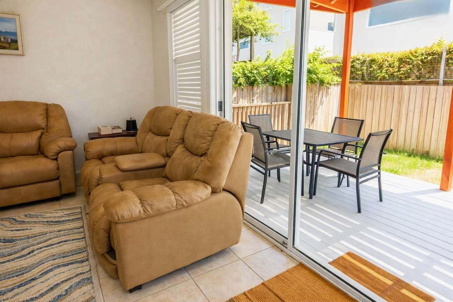 A modern living room with a sofa and a dining area with a table and chairs.