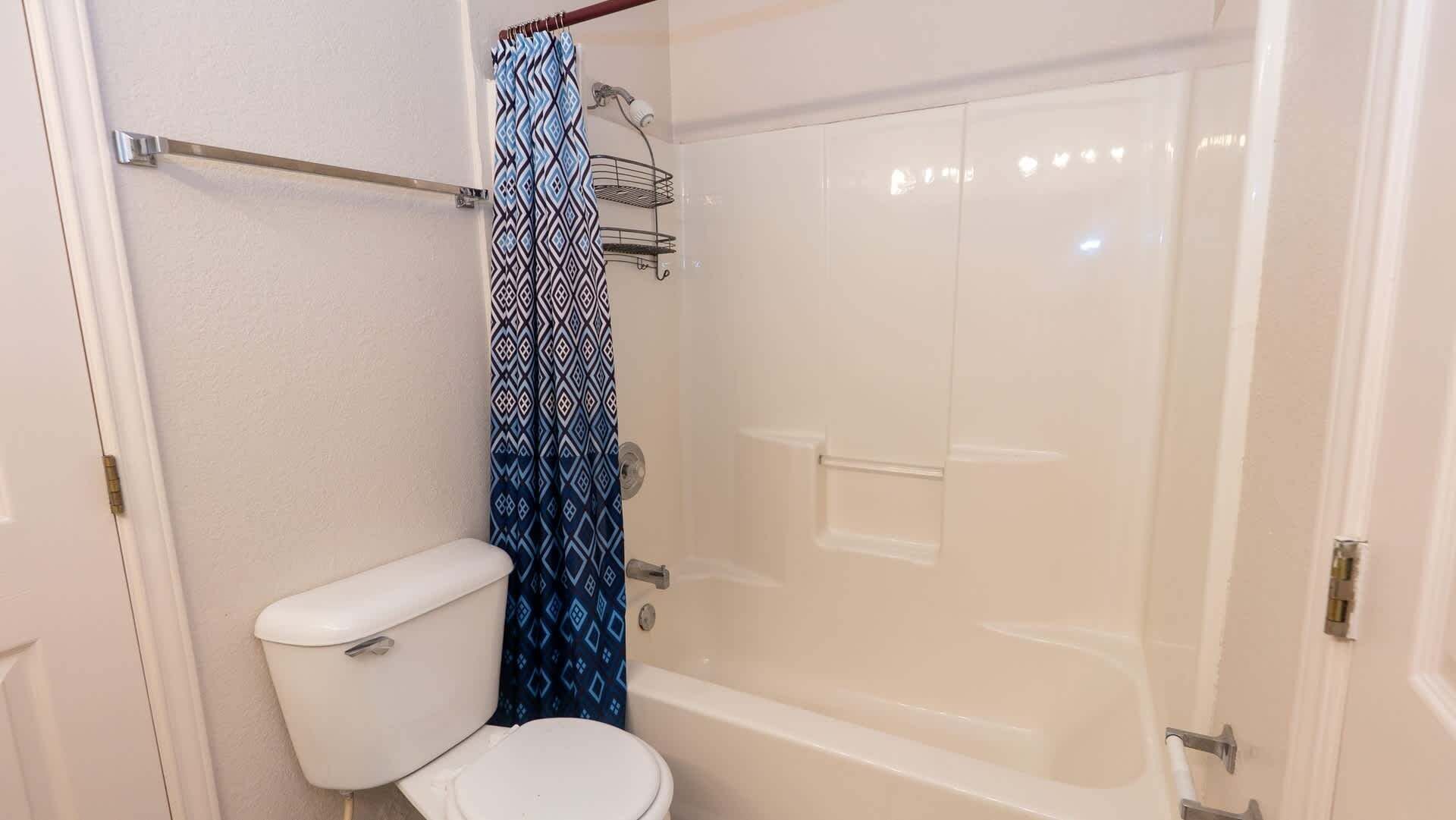 Une salle de bain équipée de toilettes, d’une douche et d’une baignoire.