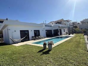 A modern house with a swimming pool, a hammock, and a well-maintained lawn. - Villa Giil - a spacious, modern, family-friendly villa with a private pool (Plaka Apokoronas)