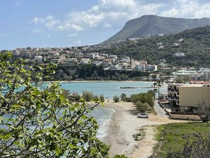 A coastal town with buildings, a beach, and a mountain in the background. - Villa Giil - a spacious, modern, family-friendly villa with a private pool (Plaka Apokoronas)