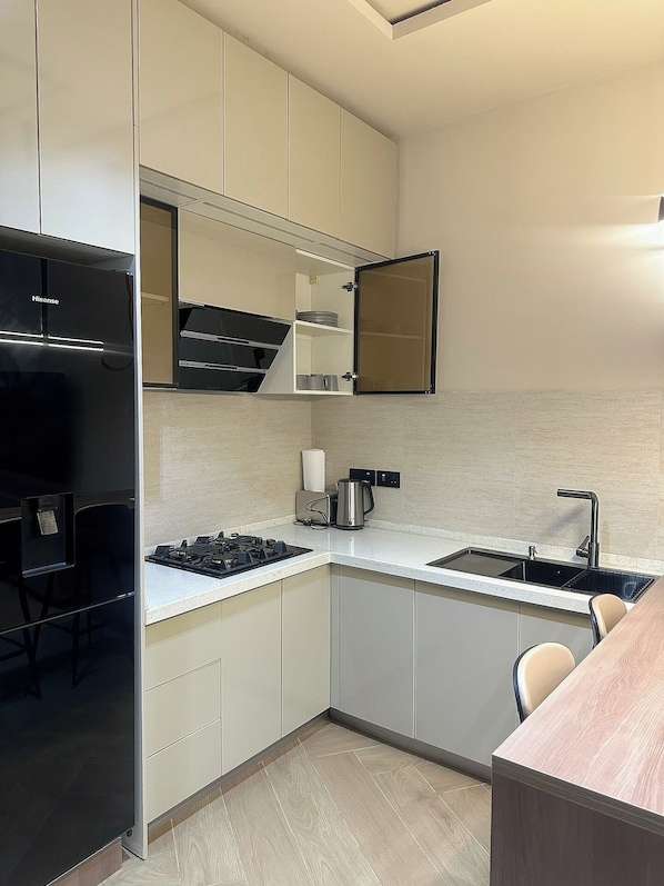 A compact kitchen with a built-in stove, a sink, and a microwave.
