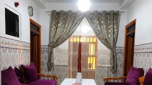 A room with two wooden sofas, a table, and a ceiling fan.
