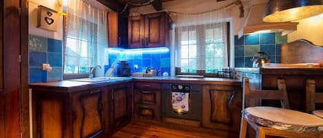 Een landelijke keuken met houten kastjes, een ingebouwde oven en een bar met krukken.