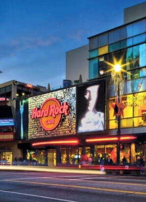 A Hard Rock Cafe with a large illuminated sign and a billboard. - Modern Studio with balcony in the heart of the Hollywood Walk of Fame area (Los Angeles)