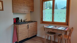 Eine Küche mit Holzausstattung, einer Kaffeemaschine und einem Fenster mit Blick auf eine Berglandschaft.