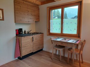 Eine Küche mit Holzausstattung, einer Kaffeemaschine und einem Fenster mit Blick auf eine Berglandschaft.