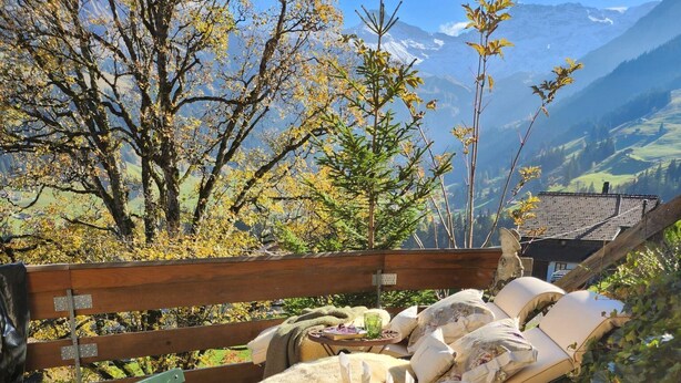 Ein Essbereich im Freien mit Tisch für zwei Personen mit Blick auf eine Berglandschaft.