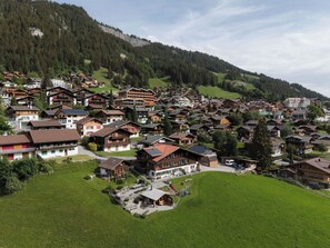 A mountainous village with traditional wooden houses, a central building with a sloped roof, and a playground. - Gästehaus Alpengruss Appartement/Fewo, Bad, WC, 1 Schlafraum by Interhome (Adelboden)