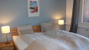 Ein Schlafzimmer mit einem Bett, zwei Nachttischen und einem Bild an der Wand.