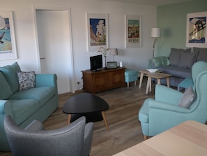 A modern living room with teal sofas, a black coffee table, and a wooden cabinet. - Gruebi - Haus Baldrian Appartement/Fewo, Bad, WC, 2 Schlafräume 3-Zimmerwohnung by Interhome (Adelboden)