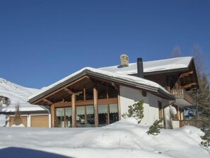 A wooden chalet with a sloped roof and large windows, surrounded by snow. - Chalet Sturmfang Appartement/Fewo, Dusche und Bad, WC, 4 oder mehr Schlafräume by Interhome (Adelboden)