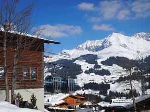 A mountain village with a wooden building, a ski lift, and snow-covered peaks. - Studio Riseten Appartement/Fewo, Dusche, WC, 1 Schlafraum 1-Zimmerwohnung by Interhome (Adelboden)