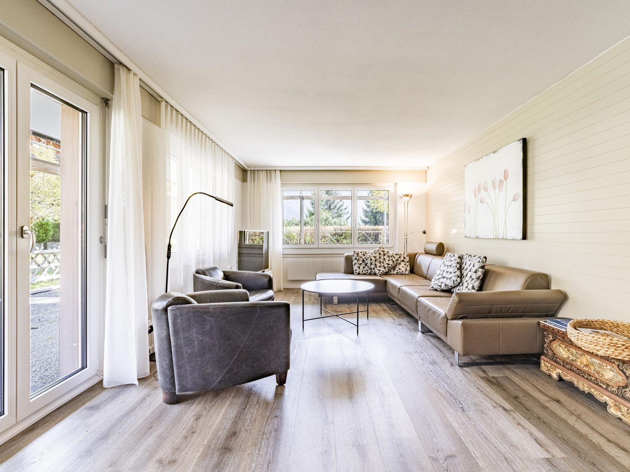 A spacious living room with a sofa set, a coffee table, and a floor lamp.