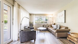 A spacious living room with a sofa set, a coffee table, and a floor lamp. - Rapunzel Paterre B25 Appartement/Fewo, Dusche, WC, 2 Schlafräume by Interhome (Adelboden)