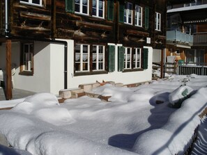 A snow-covered building with multiple windows and a wooden facade. - Hagrösli Appartement/Fewo, Dusche, WC, 1 Schlafraum 2-Zimmerwohnung by Interhome (Adelboden)