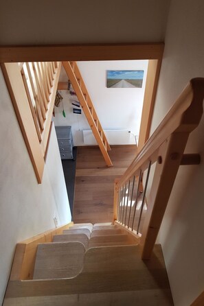 A wooden staircase leading to a room with a view of a road and a painting on the wall. - Chalet Giisställi Ferienhaus, Dusche, WC Ferienhaus by Interhome (Adelboden)