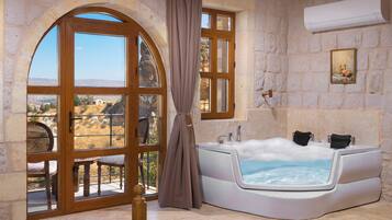 Una habitación con un amplio arco de entrada, un jacuzzi y vistas a un paisaje montañoso.