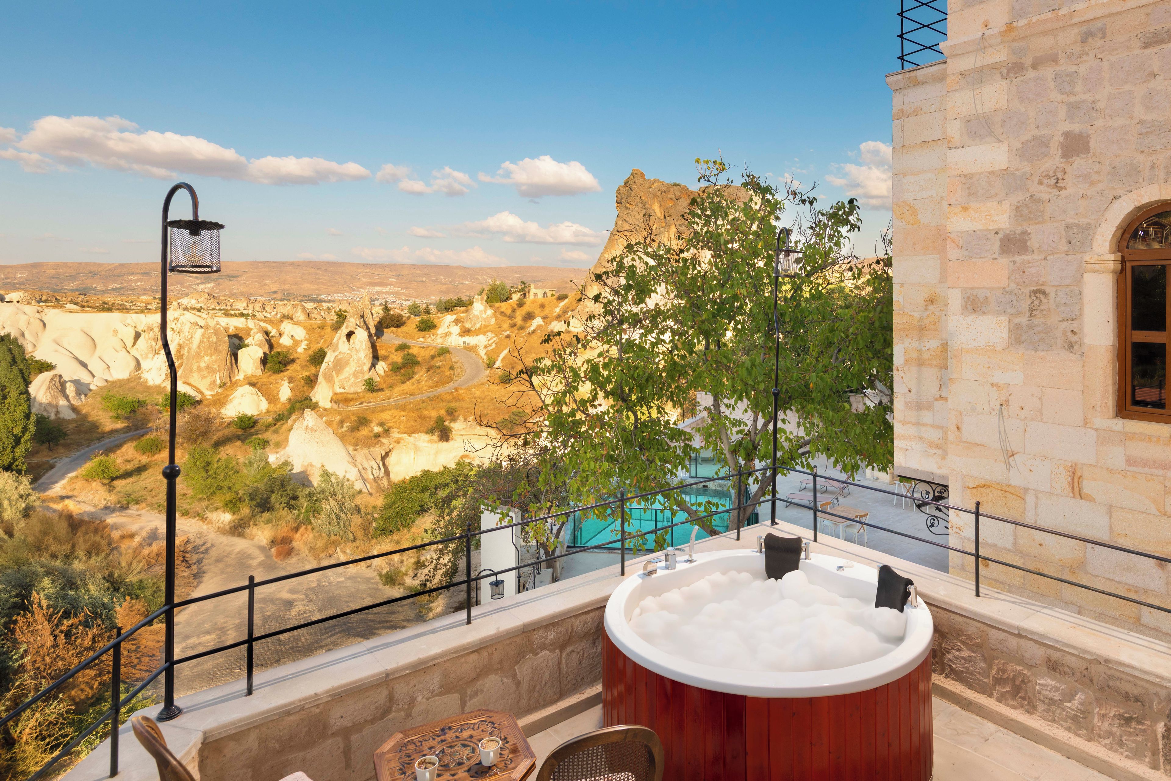 Un jacuzzi con vistas a un paisaje montañoso y una piscina.