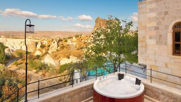 Un jacuzzi con vistas a un paisaje montañoso y una piscina.