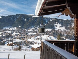 A snowy mountain village with wooden buildings and a hanging bucket. - Chalet Iris Appartement/Fewo, Dusche, WC, 2 Schlafräume 3-Zimmerwohnung by Interhome (Adelboden)