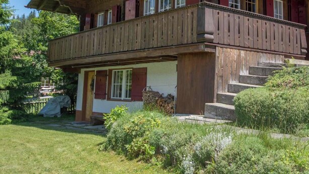 A traditional wooden chalet with a balcony, a front entrance, and a staircase leading to the upper floor. - Chalet Iris Appartement/Fewo, Dusche, WC, 2 Schlafräume 3-Zimmerwohnung by Interhome (Adelboden)