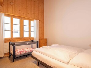 A room with a bunk bed, a wooden wardrobe, and a window with curtains. - Am Gilsbach 1 Appartement/Fewo, Dusche und Bad, WC, 3 Schlafräume by Interhome (Adelboden)