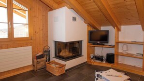 Una stanza accogliente con camino, televisione su un mobile in legno e tappeto in pelle di vacca.