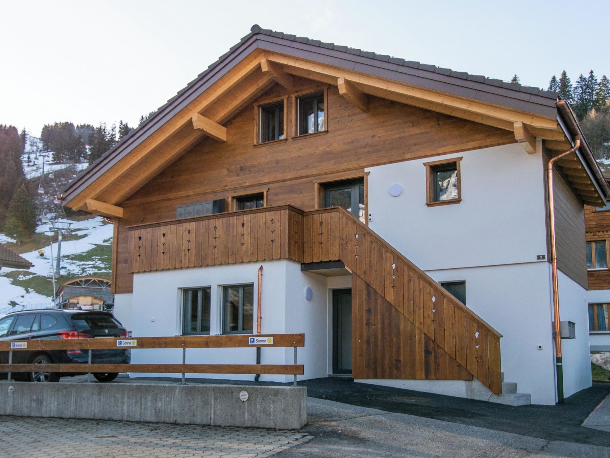 Ein zweistöckiges Gebäude mit einem hölzernen Balkon und einer Treppe, die zu dem oberen Stockwerk führt.