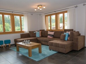 Una sala de estar con un sofá modular, una mesa de centro y dos sillas azules.