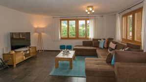 A living room with a television, sofa, coffee table, and windows. - Schützenrain 1. Stock Appartement/Fewo, Bad, WC, 3 Schlafräume by Interhome (Adelboden)