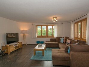 A living room with a television, sofa, coffee table, and windows. - Schützenrain 1. Stock Appartement/Fewo, Bad, WC, 3 Schlafräume by Interhome (Adelboden)