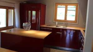 A modern kitchen with a central island, a built-in oven, and a window above the sink. - Haus Baumann Appartement/Fewo, Bad, WC, 4 oder mehr Schlafräume 5 Zimmerwohnung by Interhome (Adelboden)