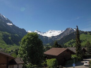 A mountain village with traditional wooden houses, a clear sky, and snow-capped peaks in the background. - Titschermatte Appartement/Fewo, Bad, WC, 2 Schlafräume 3-Zimmerwohnung by Interhome (Adelboden)