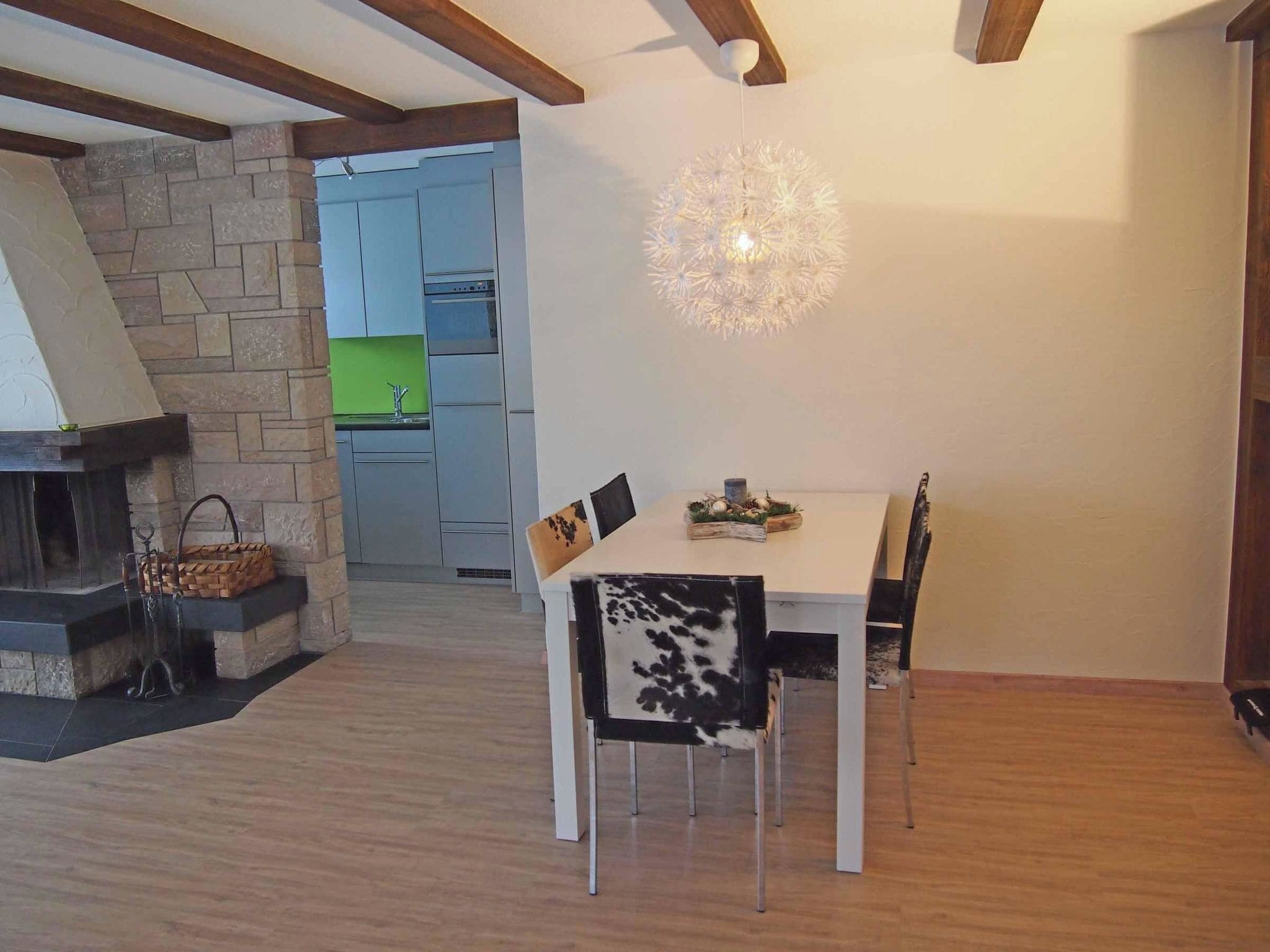 Un espace repas comprenant une table, des chaises et un luminaire suspendu.