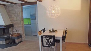 A dining area with a table, chairs, and a hanging light fixture. - Helios Appartement/Fewo, Dusche, WC, 3 Schlafräume 4-Zimmerwohnung by Interhome (Adelboden)