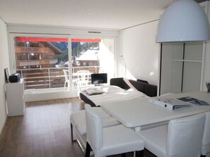 Ein modernes Hotelzimmer mit Balkon, Essbereich und großem Fenster.