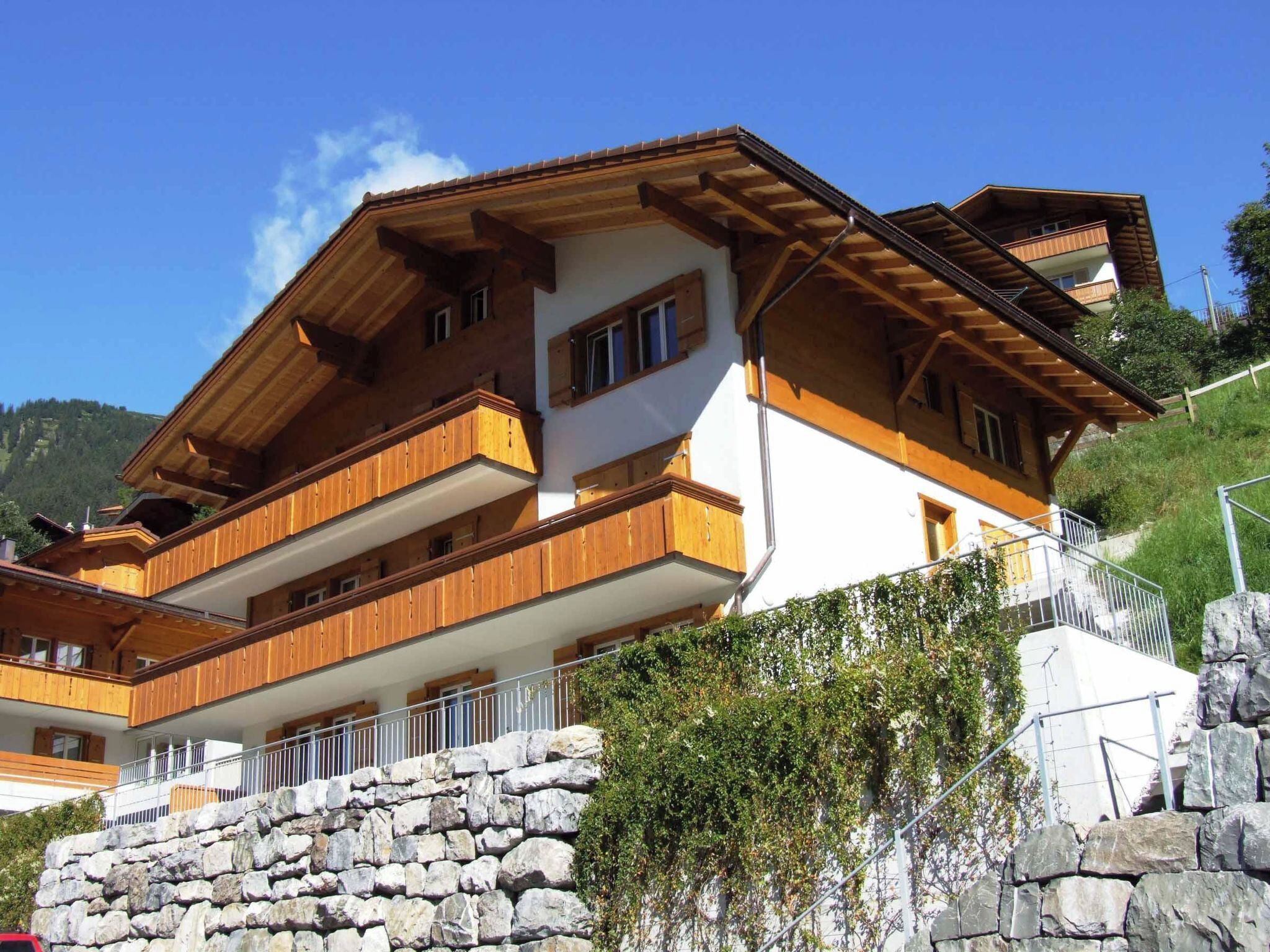 A multi-story chalet with wooden balconies and a stone foundation.