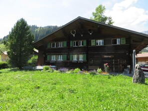 A wooden chalet with a sloped roof, multiple windows, and a front porch. - Stockbrunä Appartement/Fewo, Bad, WC, 2 Schlafräume by Interhome (Adelboden)