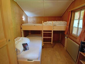 A compact room with two bunk beds, a ladder, a radiator, and a window with curtains. - Stockbrunä Appartement/Fewo, Bad, WC, 2 Schlafräume by Interhome (Adelboden)